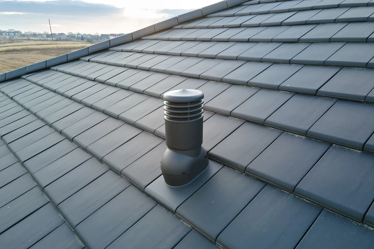 Dark gray tile roof with a black vent.